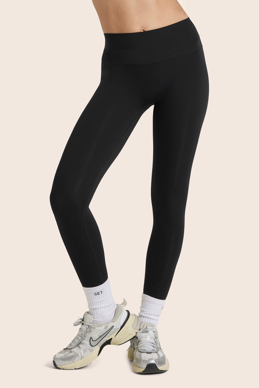 MODEL WEARS AIRLUXE™ BREATHE MID-RISE LEGGINGS IN ONYX