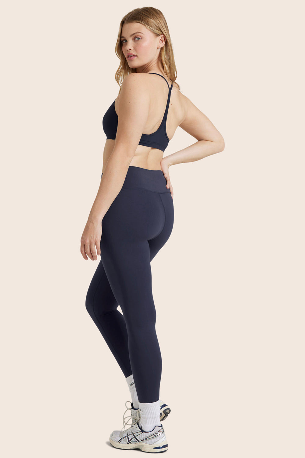 MODEL WEARS AIRLUXE™ BREATHE MID-RISE LEGGINGS IN SPADES