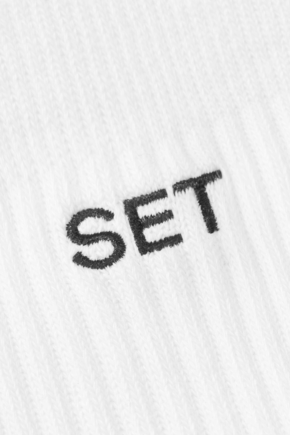 CLOSE UP IMAGE OF 'SET' EMBROIDERY IN SOCKS