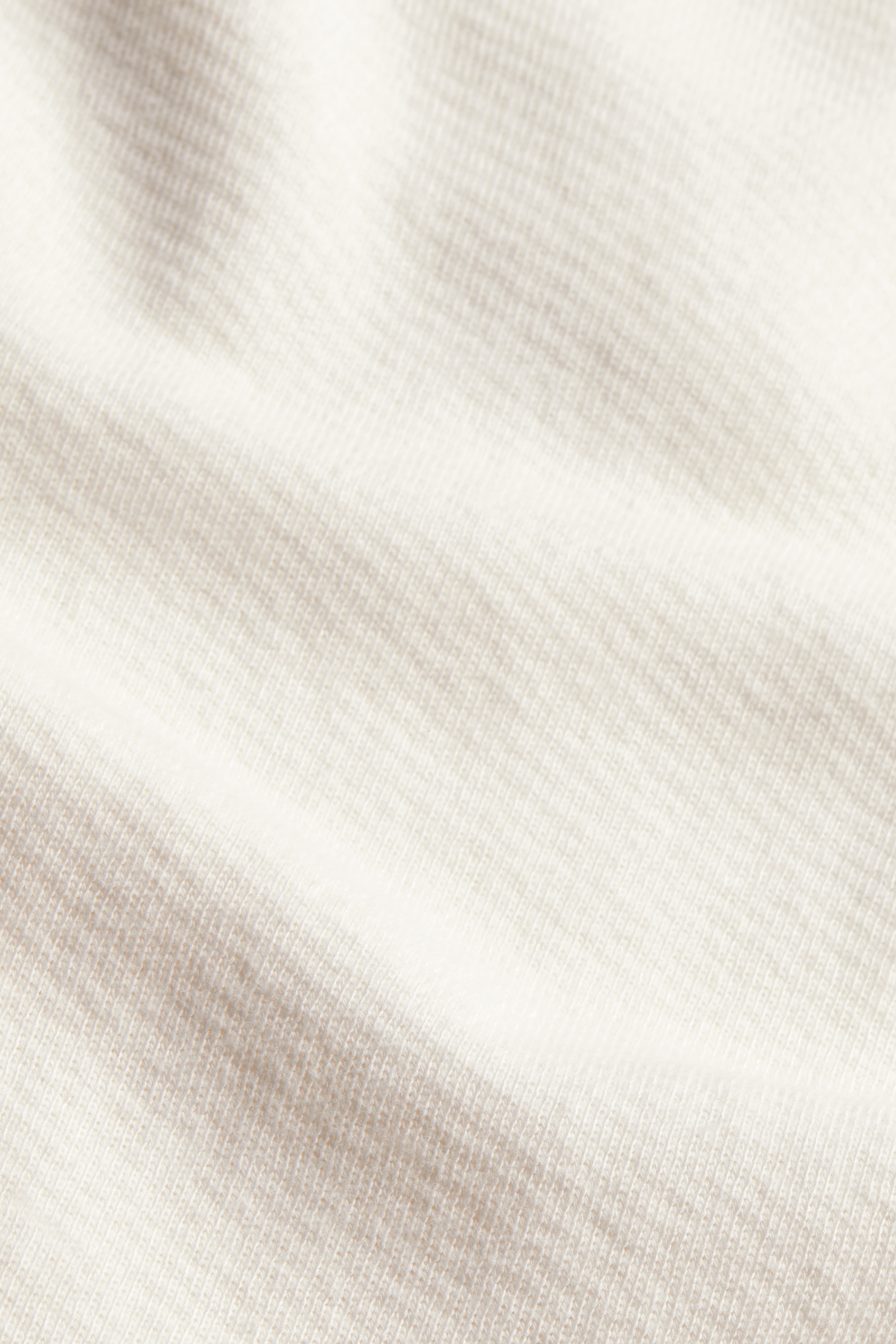 CLOSE UP IMAGE OF LIGHTWEIGHT SWEATS FABRIC IN BLANC